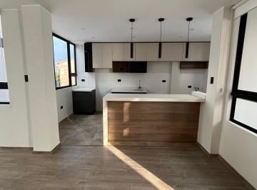 Cocina moderna integrada al área social. · Departamento en Venta Higuereta | 67 m² | Techos Altos y Excelente Iluminación