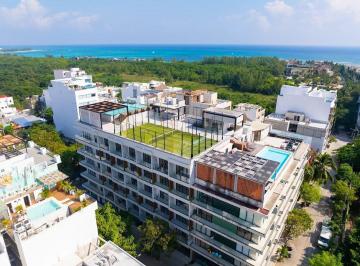 una vista aerea de un edificio con una cancha de padel en macondo playa del carmen · Departamento de 1 Recámara en Renta | Macondo 5th Av Playa del Carmen | a Pasos de La Playa