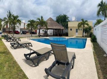 una alberca comun con camastros y areas verdes en fraccionamiento playa azul playa del carmen · Casa de 3 Recámaras Sin Muebles en Renta | Residencial Playa Azul Playa del Carmen