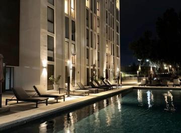 Alberca iluminada en área común nocturna · Departamento Tipo Suite en Renta en The Lighthouse Zapopan Jal